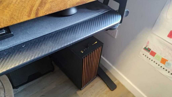 Desktop PC tower tucked away under standing desk