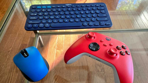 Xbox controller, keyboard, and mouse on a glass table